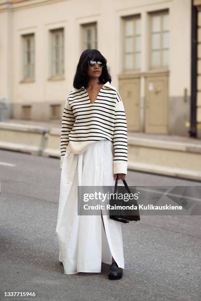 Chili Bendt wearing white long skirt, striped black and white sweater and black bag during Stockholm fashion week Spring/Summer 2022 on September 01,...