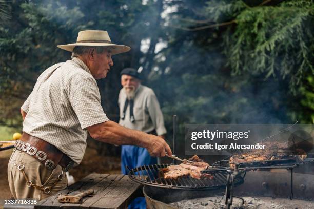 gaucho preparing barbecue in the countryside - argentinsk kultur bildbanksfoton och bilder