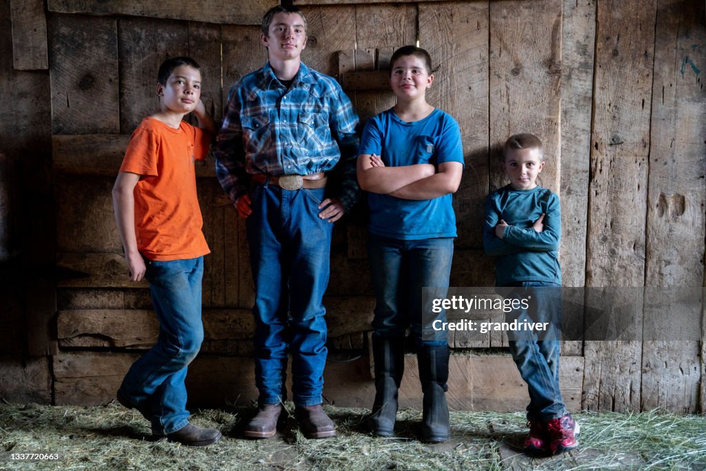 Portrait of Four Young brothers posing inside a rustic barn on a ranch in the rocky mountains of colorado near telluride