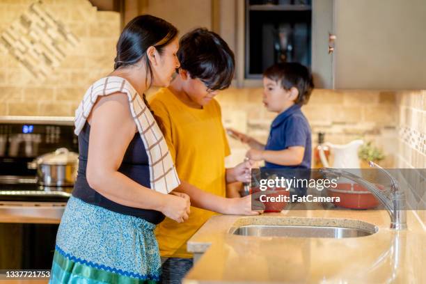 indigenous mother cooking a meal with her two sons - indian food bildbanksfoton och bilder