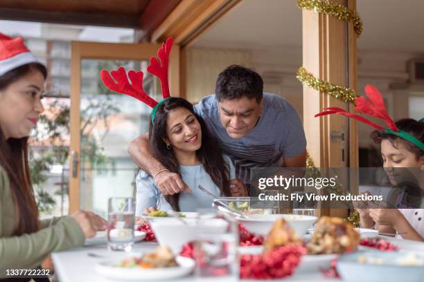 happy couple enjoying christmas at home - mom flirting stockfoto's en -beelden