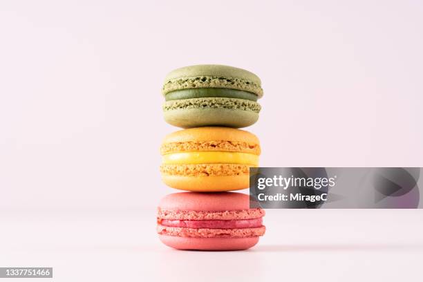 pastel colored macaroons stack against pink - macaron stock pictures, royalty-free photos & images