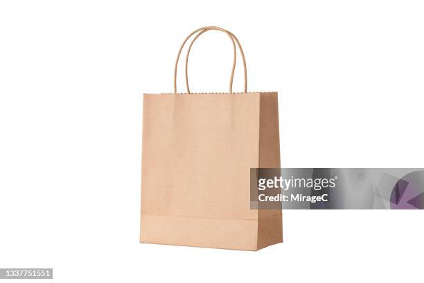 brown paper shopping bag on white - tragetasche oder tragebeutel stock-fotos und bilder