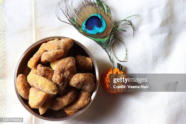 sharkara varatti/upperi/jaggery coated banana chips in brass uruli/kerala/onam festival - jaggery stock pictures, royalty-free photos & images