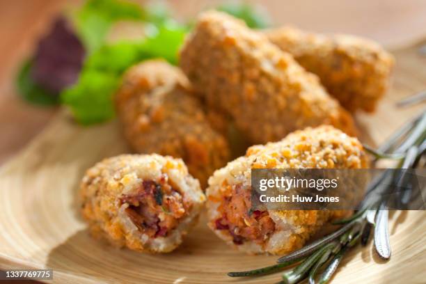 close up deep fried bean croquettes, one shown broken open in the foreground - fried potato stock pictures, royalty-free photos & images