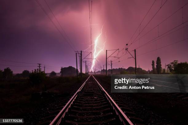 lightning over the railroad at night - train tracks and nature foto e immagini stock
