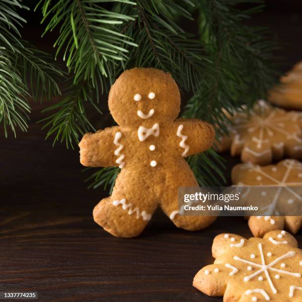 gingerbread men on wooden background, christmas baking - figurita de jengibre fotografías e imágenes de stock