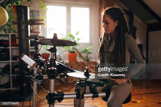 情熱的な女性ミュージシャン、ドラマー、彼女のスキルを練習する彼女のスタジオで - ドラム ストックフォトと画像