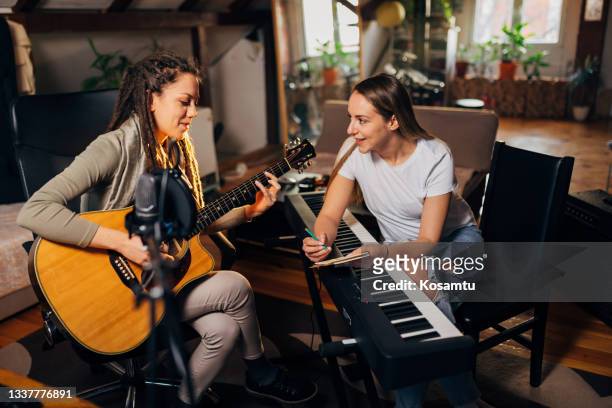 female composer hands writing a song on pad in recording studio - songwriter stock pictures, royalty-free photos & images