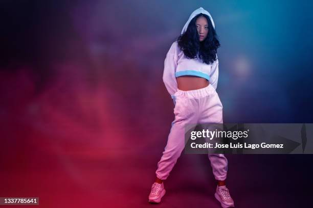 young chinese girl with hip hop aesthetics, looking forward with attitude and pose according to her musical tendency. - the way forward stock-fotos und bilder