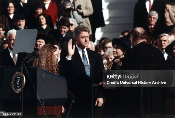 Bill Clinton, standing between Hillary Rodham Clinton and Chelsea Clinton, taking the oath of office of president of the United States, Washington,...