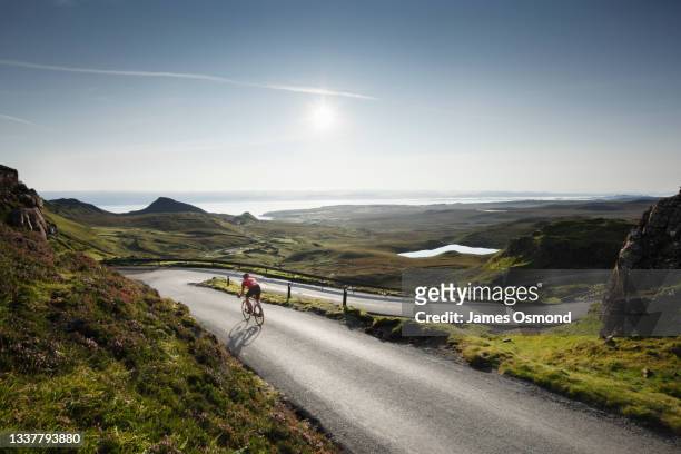 road cyclist on descent of the quiraing. - cycling scotland stock pictures, royalty-free photos & images
