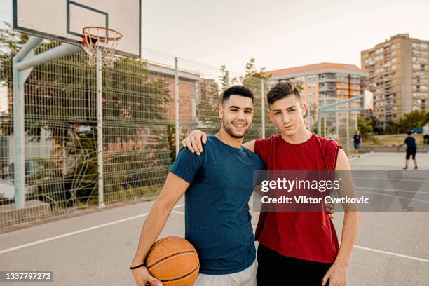 two men posing on a basketball court - match basket stock pictures, royalty-free photos & images