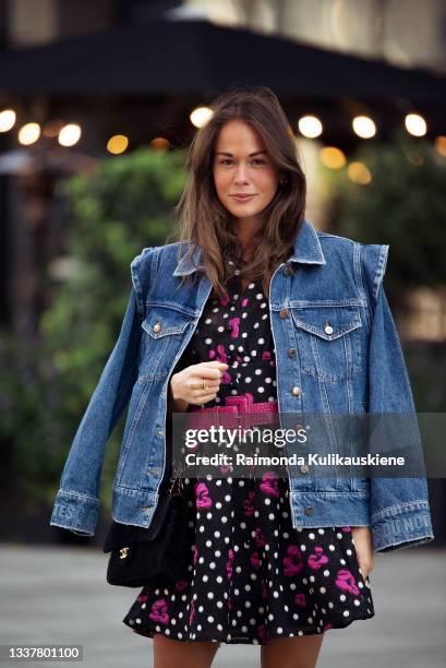 Therese Hellstrom wearing black dress with white and pink ornaments, pink leather belt, reptile skin imitation shoes, denim jacket and balck Chenel...