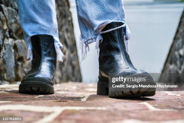 boots of a young woman on a stone floor - bota imagens e fotografias de stock