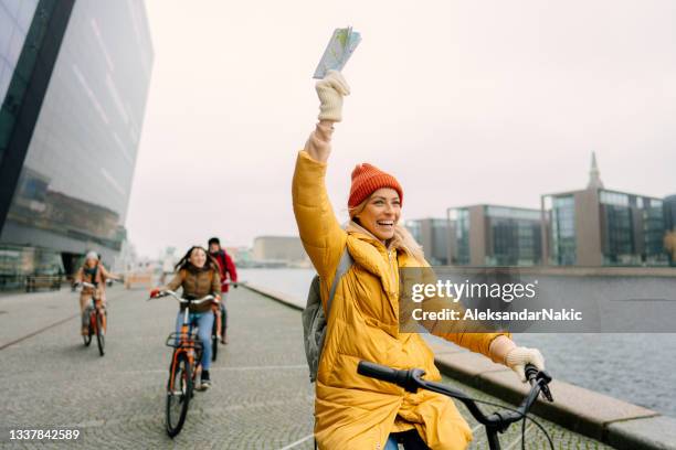 guide de voyage et son groupe sur les vélos à travers la ville - guide touristique photos et images de collection