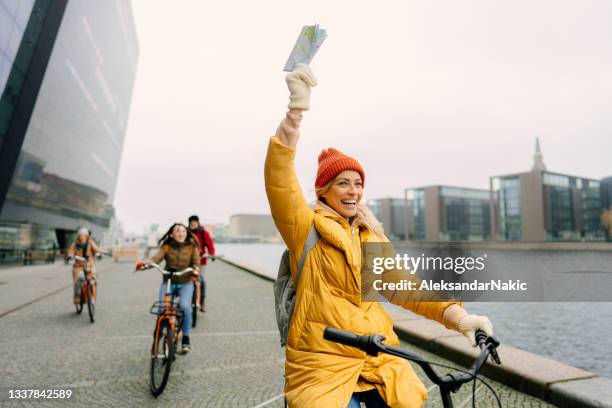 町を自転車に乗った旅行ガイドと彼女のグループ - 案内 ストックフォトと画像