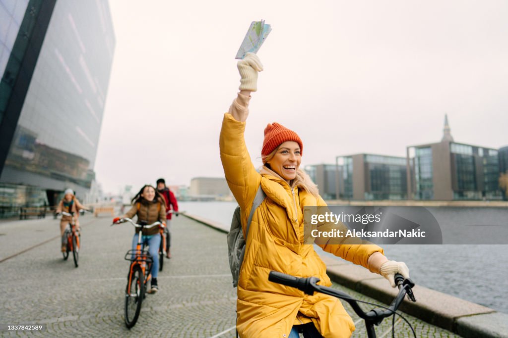 Travel guide and her group on the bicycles through the town