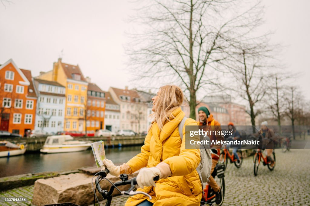Travel guide and her group on the bicycles through the town