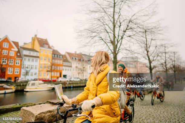 travel guide and her group on the bicycles through the town - copenhagen stock pictures, royalty-free photos & images