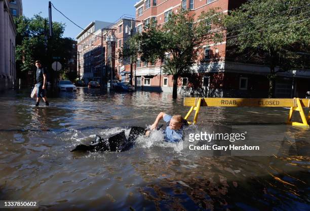 Man falls off his bike into a flooded street the morning after the remnants of Hurricane Ida drenched the New York City and New Jersey area on...