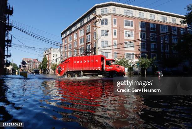 Sanitation truck drives through a flooded street the morning after the remnants of Hurricane Ida drenched the New York City and New Jersey area on...