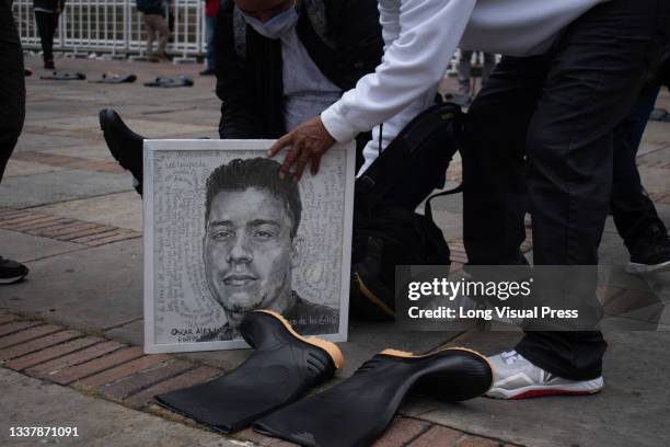 Close relative places a drawing of Oscar Alexander a young male killed during the commemoration of the international day of the victims of force...