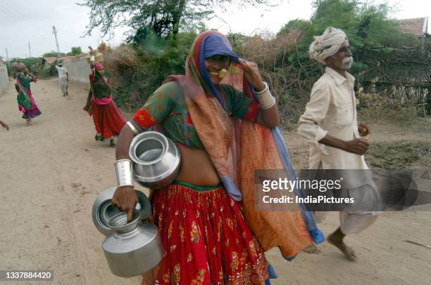 Tribal women carrying pots.