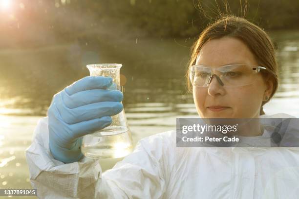 scientist holding water sample up to light - testing the water engelse uitdrukking stockfoto's en -beelden