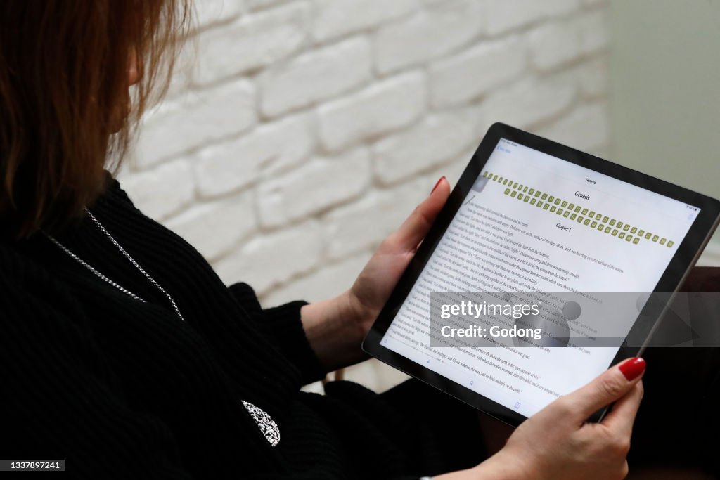 Woman reading the bible  on a  digital tablet Ipad