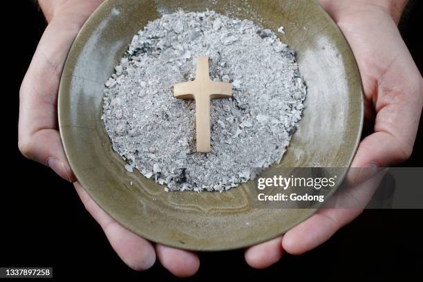 Close-up on hands and ashes. Ash Wednesday celebration. Lent season. France.