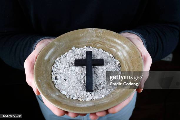 Close-up on hands and ashes. Ash Wednesday celebration. Lent season. France.