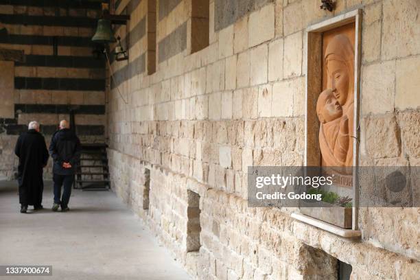 Lay man and benedictine monk in San Pietro di Sorres basilica cloister, Sardinia, Italy.