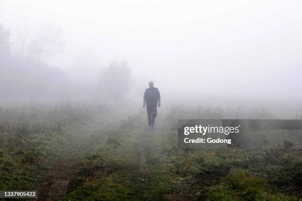 Man walking in a foggy landscape in Krtova village, Bosnia & Herzegovina.