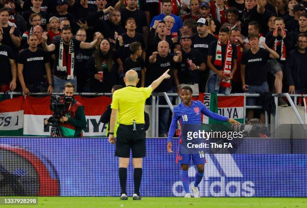 Raheem Sterling of England talks to referee Cuneyt Cakır during the 2022 FIFA World Cup Qualifier match between Hungary and England at Stadium Puskas...