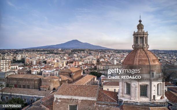 Aerial view of the dome and roofs of the Benedictine Monastery and in the background the Etna Volcano. Catania. Sicily. Italy. Europe.