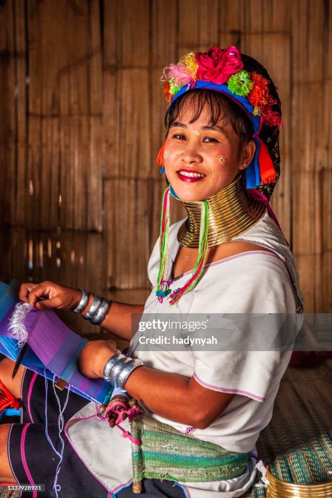 Young woman from Long Neck Karen tribe weaving on a traditional loom