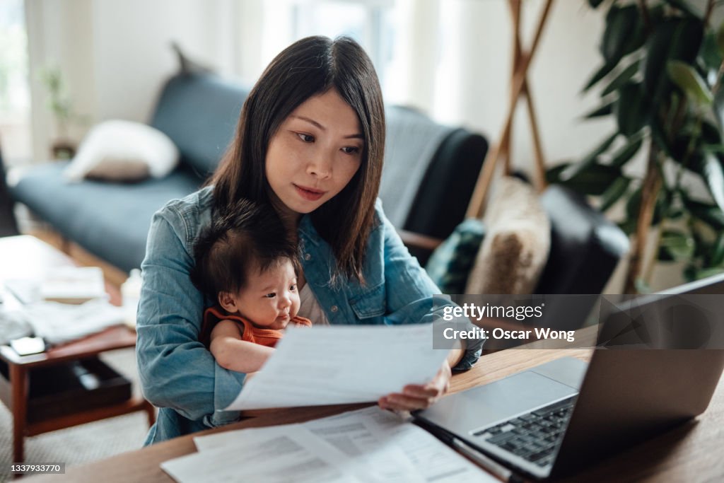 Young mother with baby daughter working from home