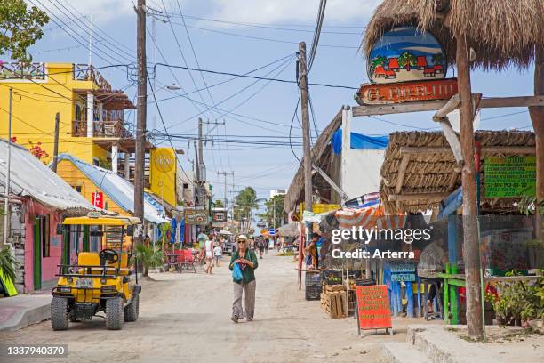 Western tourist walking in street on Isla Holbox, island in the Mexican state of Quintana Roo, along the north coast of the Yucat‡n Peninsula, Mexico.