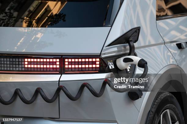 electric car on a public charging point on a street - hyundai stock pictures, royalty-free photos & images