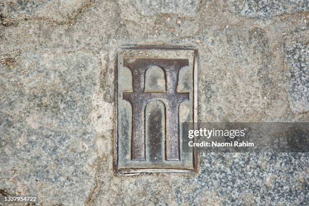 paving stone with engraving of a roman aqueduct icon in segovia, spain - bridge logo stock-fotos und bilder