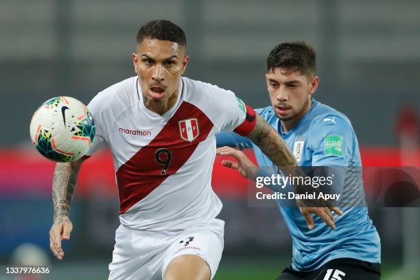 Paolo Guerrero of Perú competes for the ball with Federico Valverde of Uruguay during a match between Peru and Uruguay as part of South American...