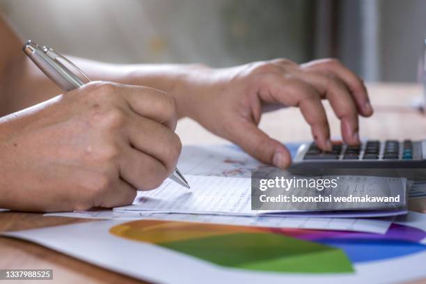 asian woman calculates monthly expenses from book bank statement. - maandelijkse gebeurtenis stockfoto's en -beelden