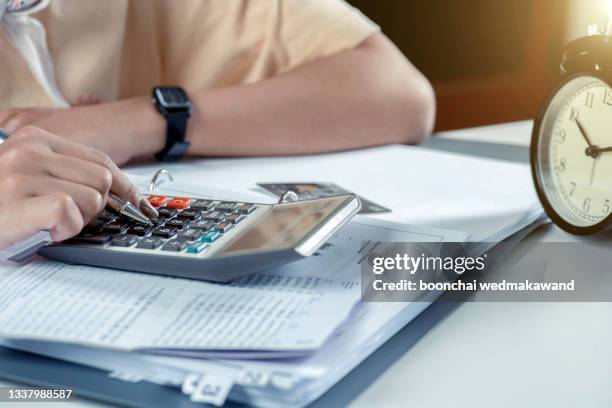 a man using calculator working with bank report statement. - bank statement stock pictures, royalty-free photos & images