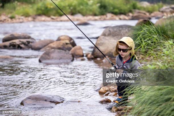 cute redhead boy fishing in the river in quebec - trout fishing stock pictures, royalty-free photos & images