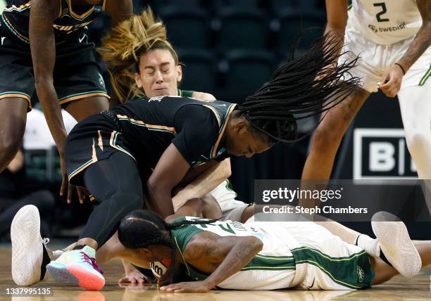 Michaela Onyenwere of the New York Liberty fights for the ball against Breanna Stewart and Jewell Loyd of the Seattle Storm during the first quarter...