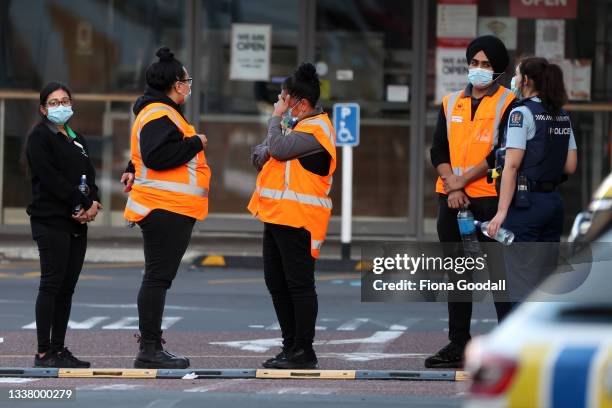 Countdown LynnMall staff comfort each other as they wait to leave with police after a violent extremist took out a terrorist attack stabbing six...