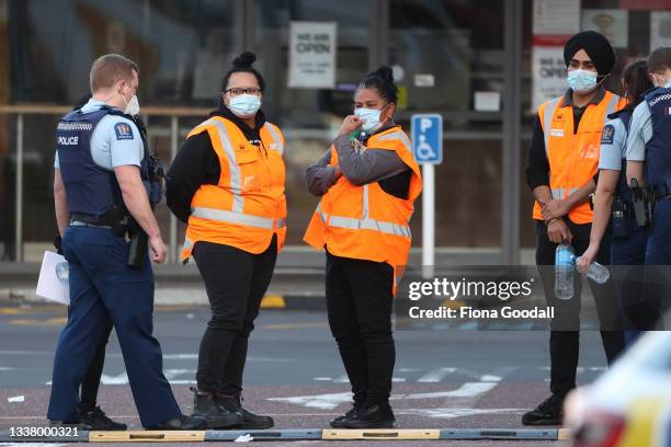 Countdown LynnMall staff comfort each other as they wait to leave with police after a violent extremist took out a terrorist attack stabbing six...