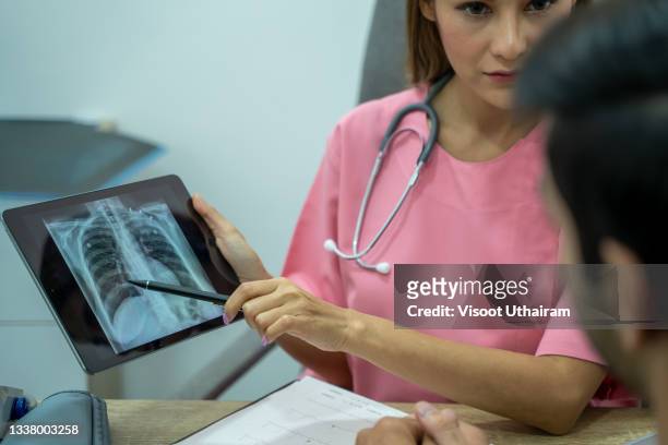 chest x-ray images of patient to disease lung,doctor explaining the results of scan lung on digital tablet screen to patient. - lunge krank stock-fotos und bilder