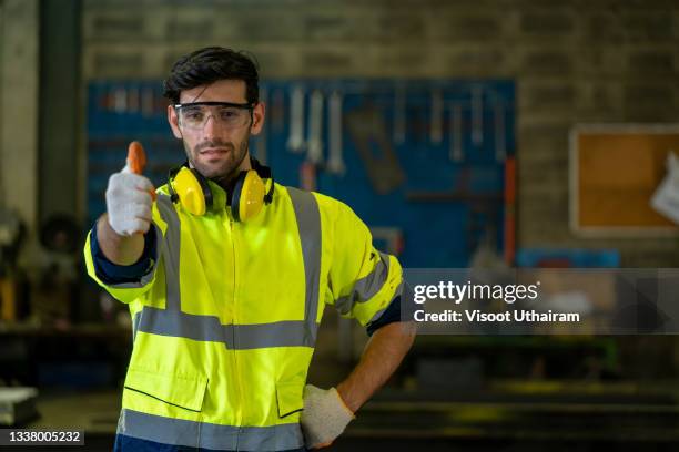 industry worker wearing safety uniform standing in factory. - workers compensation - fotografias e filmes do acervo
